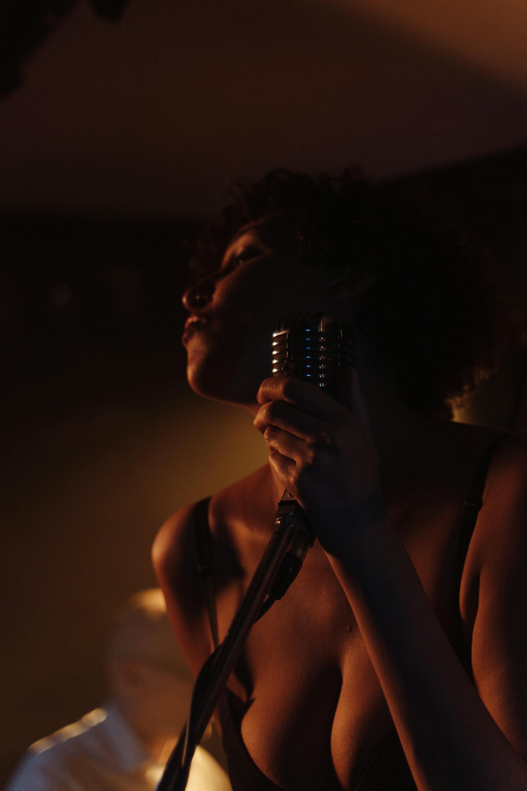 A Woman in Black Spaghetti Strap Top Singing